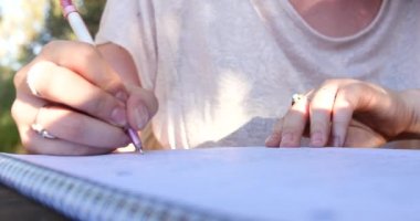 Not defterinde mektup yazma / açık havada okuyan kadın