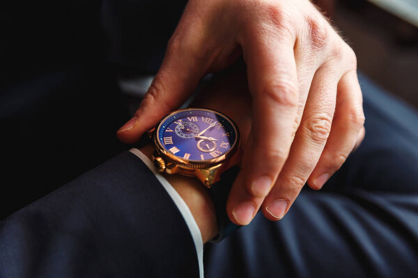 Businessman holding a watch