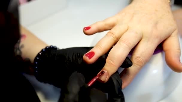 Manicure procedure. putting red polish on finger nail — Stock Video