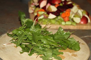 Karahindiba bırakır ve meyve ve sebze ahşap kurullarında doğranmış