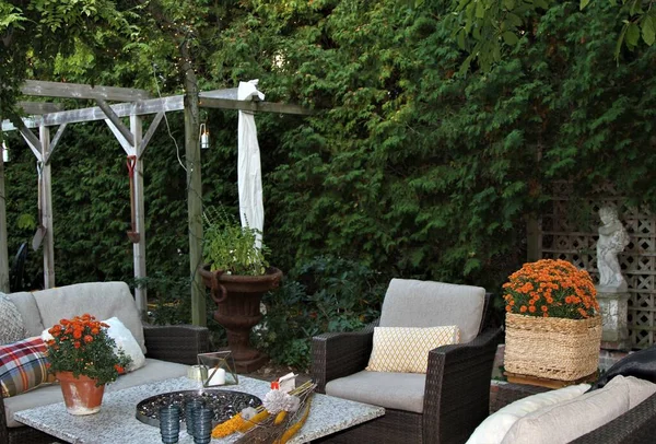 Outdoor seating arrangement around a gas fire pit table in the fall