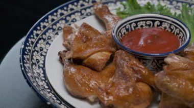 Orta Asya usulü kızarmış tavuğu süslemeli bir tabakta yavaşça kapatın.