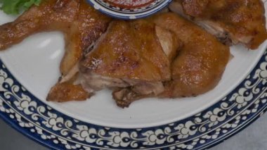 Orta Asya usulü kızarmış tavuğu süslemeli bir tabakta yavaşça kapatın.