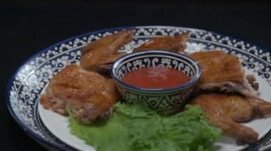 Orta Asya usulü kızarmış tavuğu süslemeli bir tabakta yavaşça kapatın.