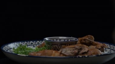 Orta Asya usulü kızarmış tavuğu süslemeli bir tabakta yavaşça kapatın.