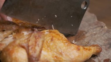 Ağır çekimde büyük bıçaklı bir adam tarafından kesilmiş kızarmış tavuk.