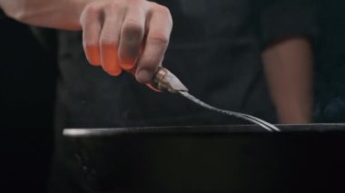 Ağır çekimde ızgarada büyük çatalı kapatın. Büyük bir çatalla ızgarayı ağır çekimde pişirin.