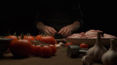 Şef bütün tavuğu sebze ve sarımsak ile masada kızarması için hazırlar.