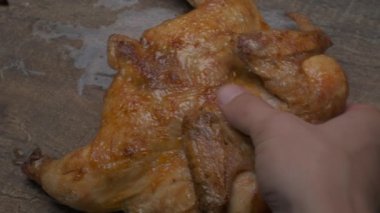 Şef ızgara tavuğu büyük bir bıçakla yavaş çekimde kesmeye hazırlanıyor.