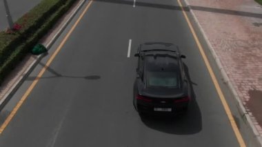 Kamera, Meydan, Dubai 'deki kavşağın altındaki siyah spor arabayı takip ediyor. İnsansız hava aracı