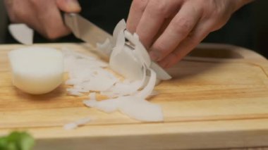 Profesyonel şef beyaz soğan hazırlar ve keser. Ağır çekimde kapat