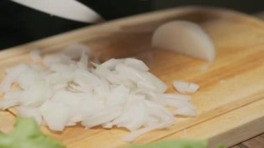 Profesyonel şef beyaz soğan hazırlar ve keser. Ağır çekimde kapat
