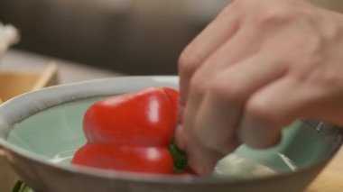Profesyonel şef kırmızı ve yeşil dolmalık biber hazırlar. Ağır çekimde kapat
