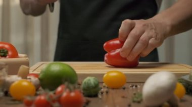 Profesyonel şef kırmızı ve yeşil dolmalık biber hazırlar. Ağır çekimde kapat