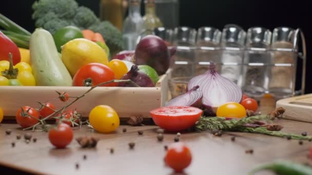 キッチンテーブルの上に新鮮な野菜やスパイス瓶 正面に赤玉ねぎをみじん切り スローモーション — ストック動画