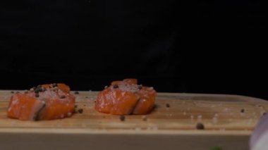 Profesyonel şef kırmızı balık bifteği ve biber serpiyor. Ağır çekimde kapat