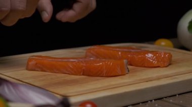 Profesyonel şef kırmızı balık bifteğini kızartma için hazırlar. Ağır çekimde kapat.