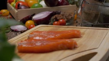 Kesme tahtasının üzerinde iki dilim somon balığı var. Ağır çekimde kapat