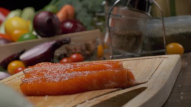 Kesme tahtasının üzerinde iki dilim somon balığı var. Ağır çekimde kapat