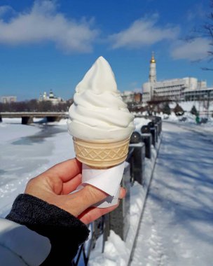 Cityscape arka plan karşı soğuk bir kış gününde kadın elinde Dondurma