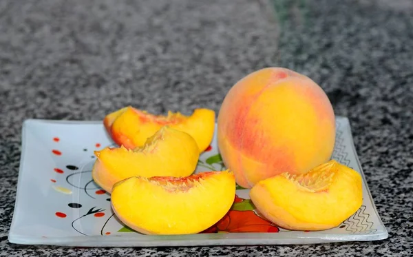 Slices of ripe juicy peach lie on a plate