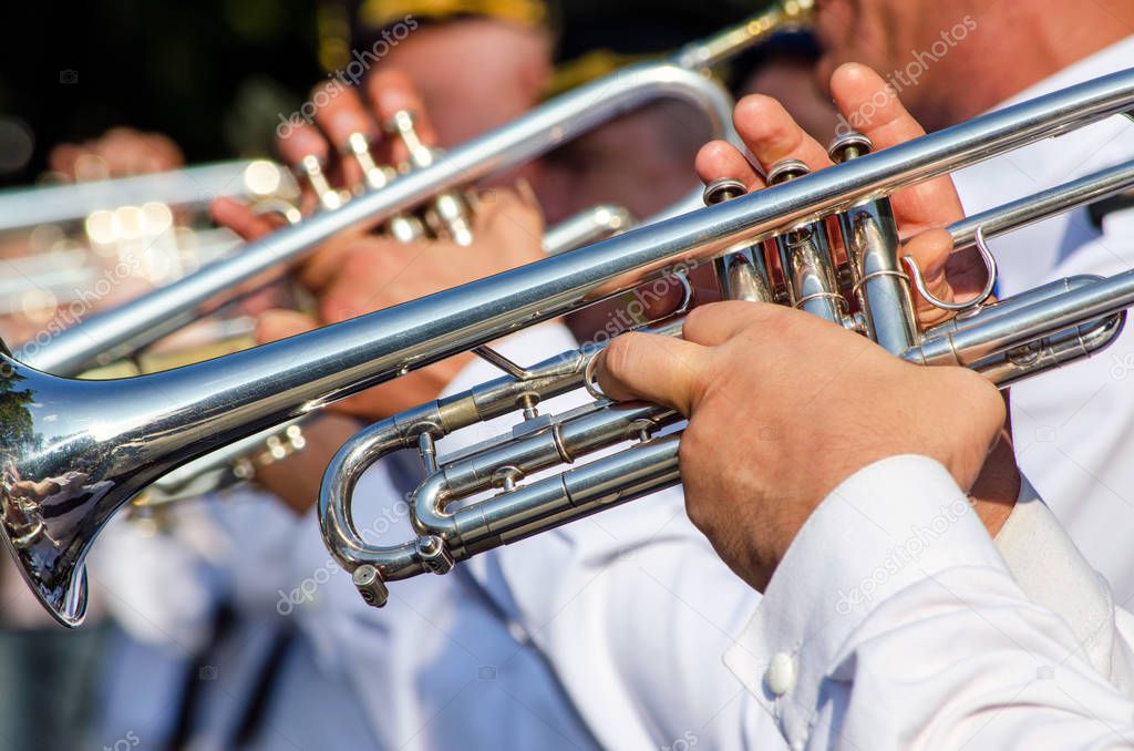 Hands of a man holding a trumpet musical instrument, a military 