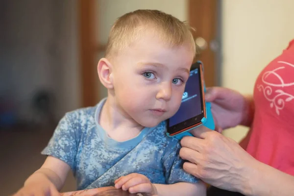 Liten Pojke Gammal Sitter Kvinnans Knä Och Lyssnar Till Mobiltelefon — Stockfoto