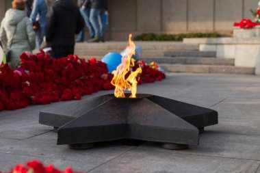 İkinci Dünya Savaşı çiçeklerle çevrili, Zafer Bayramı kutlamaları sırasında Zafer Anıtı sonsuz alev yandığı. 