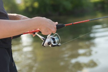 Balık tutma sırasında su üzerinde balıkçılık iplik Fisherman's ellerini tutun.