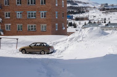 Arabayı bir konut binası avlusunda yüksek snowdrifts arasında duruyor. Kötü hava koşulları nedeniyle yol sorunları.