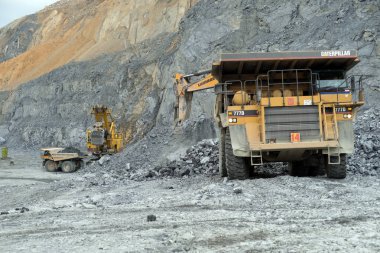Belogorsk, Rusya Federasyonu - 22 Haziran 2014: Ekskavatör Caterpillar damperli kamyon kariyer içine cevheri nefelin dökün. Maden köyü, Belogorsk içinde Kemerovo bölgesi yer alır. Sibirya, Rusya Federasyonu.