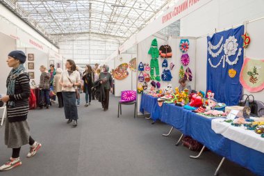 Krasnoyarsk, Krasnoyarsk Bölgesi / Rf-27 Ekim 2018: kadın yürümek ve el sanatları geleneksel geleneksel şehir Fuar Sergi salonunda büyük bir köşk içinde el yapımı ürünler bakmak.