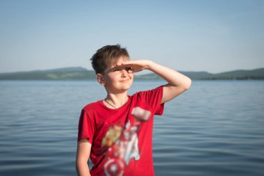 Çocuk elini korur o arka planda göl güneş güneşli bir günde gözleri.