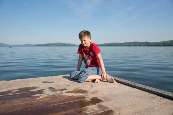 Pojken Sitter Träbrygga Och Gör Frustrerad Grimas Mot Sjön Solig — Stockfoto