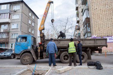 Krasnoyarsk, Krasnoyarsk Bölgesi / Rf - 30 Ekim 2018: işçi Krasnoyarsk şehir greening bir yerleşim bölgesinde ağaçlar dikim. Ağaç evlerin zemin üzerine kamyon yatıyor.