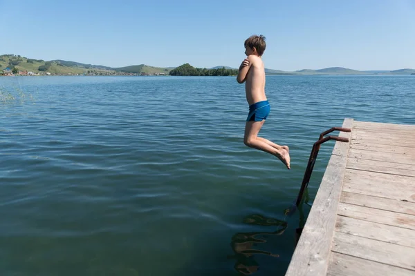 Letni Chłopiec Nurkuje Niebieski Wody Jeziora Drewnianym Molo Słoneczny Letni — Zdjęcie stockowe