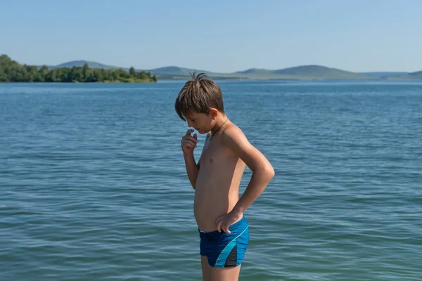 Fundersam Pojke Gammal Står Stranden Mot Bakgrund Blå Stor Sjö — Stockfoto