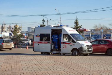 Krasnoyarsk, Krasnoyarsk Bölgesi / Rf - 30 Ekim 2018: doktor Kuzey Bölgesi, Krasnoyarsk, sonbahar park yerinde yakınındaki duruyor beyaz bir ambulans içine tırmanmaya olacaktır