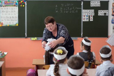 Belogorsk, Kemerovo bölgesi /Rf - Mart 22,2018: öğretmen kırsal İlköğretim Okulu Okulu sınıf okul panosunda arka planı onun masasında oturan kız öğrenci, pruvada ayarlar.