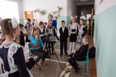 Belogorsk, Kemerovo bölgesi / Rf - 22 Mart 2018: bir kadın fotoğrafçı akıllı ilk sınıflar dersler sonra Belediye kırsal İlköğretim Okulu okul koridorunda çekiyor.