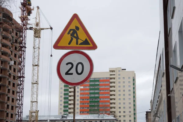 在正在施工的公寓楼和施工吊车的背景上 警示道路标志维修工作和限速标志 新西伯利亚 新西比尔斯克地区 俄罗斯 — 图库照片