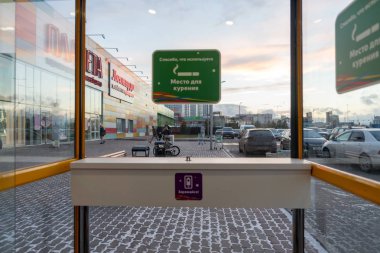 Krasnoyarsk, Krasnoyarsk Region / Rf - 1 Kasım 2018 : Akşam saatlerinde Alışveriş ve eğlence kompleksi Planet yakınlarındaki Sigara kabininde yer alan cep telefonları için masa ücretsiz Wi-Fi ve şarj cihazı.