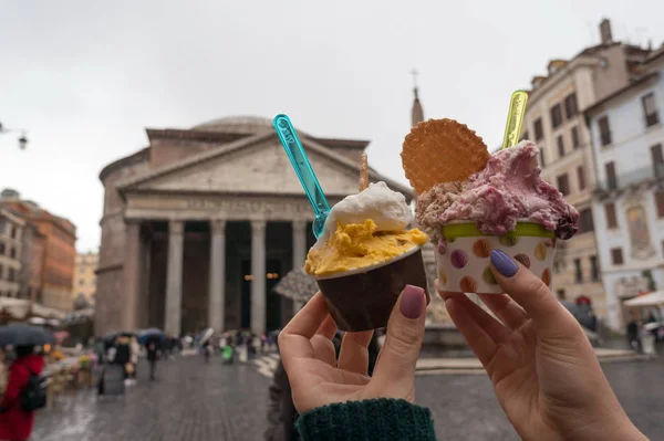 Yağmurlu bir günde İtalya'nın Piazza della Rotonda Roma Panteon karşı bir kızın elinde İtalyan dondurma iki bardak. İtalya.