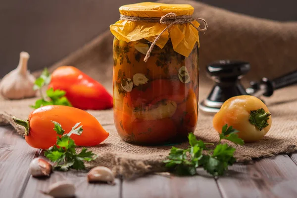 Poivrons marinés sur fond de bois rustique. Produit mariné et en conserve. Prochain ingrédients pour la cuisson et une machine pour la filature — Photo