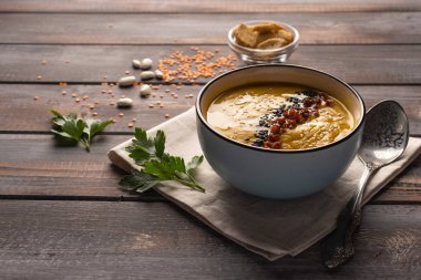 Ahşap bir arka plan üzerinde bir peçete fasulye ve baharat karışımı ile ev yapımı krema çorbası. maydanoz ile