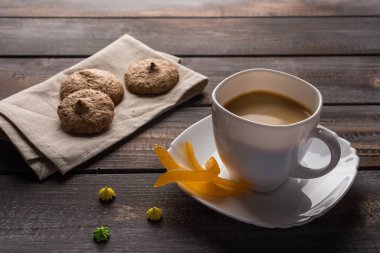 Şekerli portakal ve küçük bezeler ile siyah kahve fincan. Keten peçete üzerine kurabiye