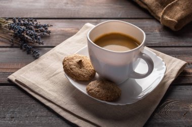 Keten peçetede bir fincan kahve. Kahve çekirdekleri ve çanta