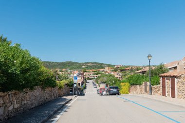 Quiet street with mountain views in Sardinia against blue sky clipart