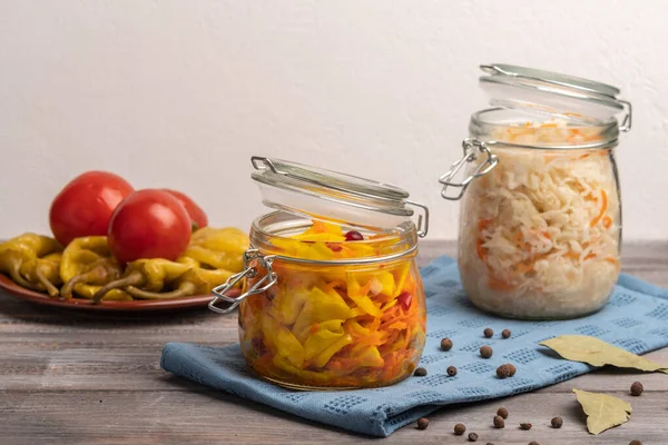 Repolho conservado em escabeche caseiro em jarros e pimentas e tomates em uma chapa cerâmica em um guardanapo de linho. Estilo rústico — Fotografia de Stock