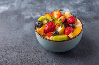 Koyu arkaplanda farklı malzemelerle taze meyve salatası. Sağlıklı beslenme. Uzayı metin için kopyala. Kapat.